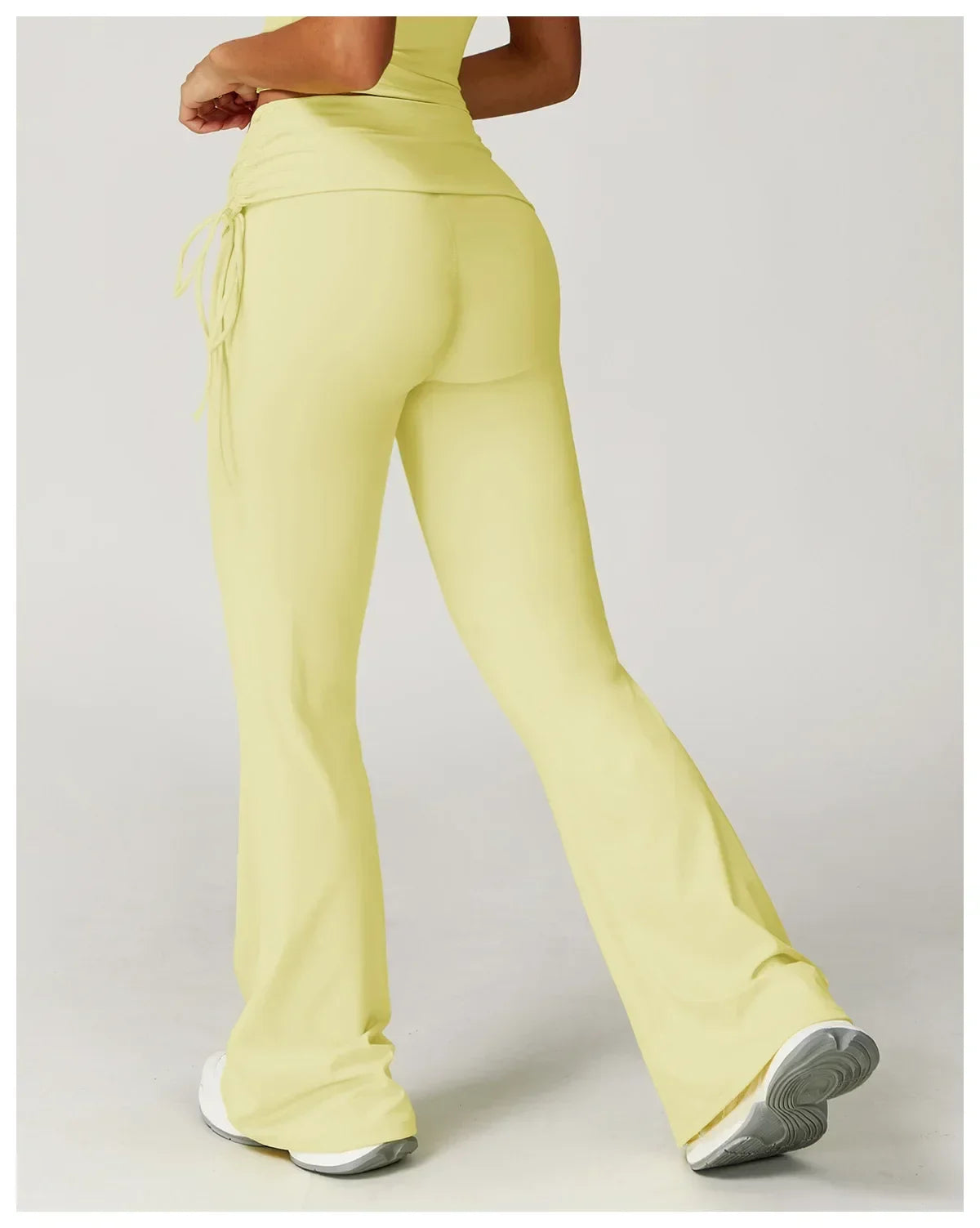 Legging évasé de sport Beauté & Santé avec cordon de serrage jaune, vue arrière, tissu extensible et confortable.